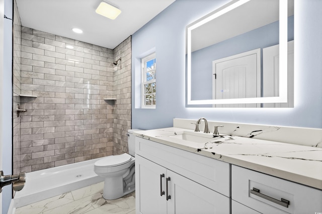 bathroom featuring tiled shower, vanity, and toilet