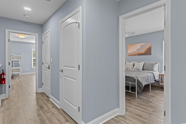hall featuring baseboards and light wood-type flooring