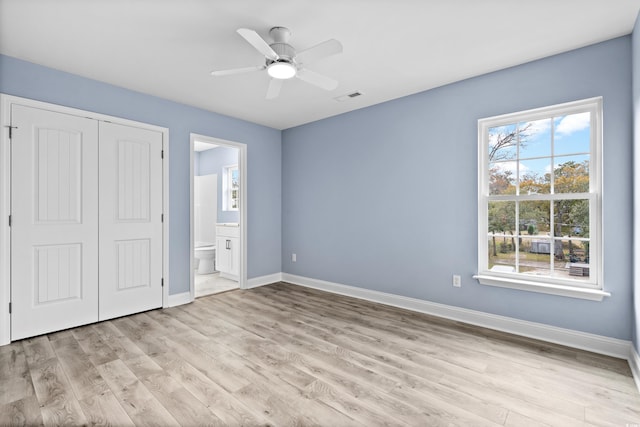 unfurnished bedroom with ceiling fan, light hardwood / wood-style floors, ensuite bathroom, and a closet