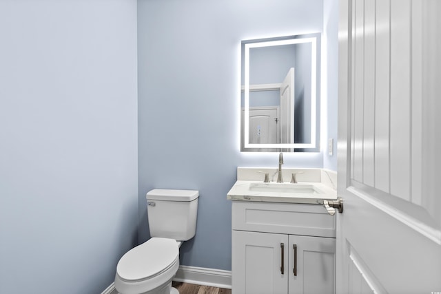 bathroom with vanity, hardwood / wood-style flooring, and toilet