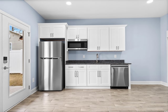 kitchen with plenty of natural light, white cabinetry, and appliances with stainless steel finishes