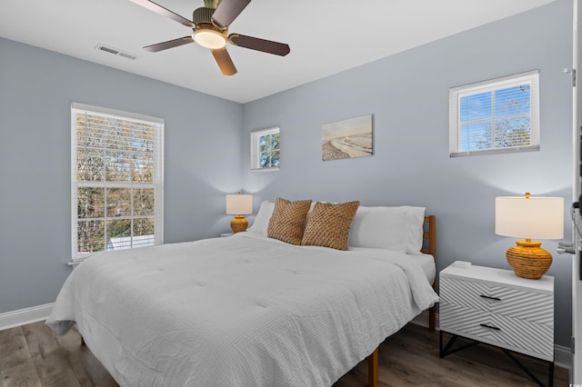 bedroom with baseboards, visible vents, wood finished floors, and ceiling fan