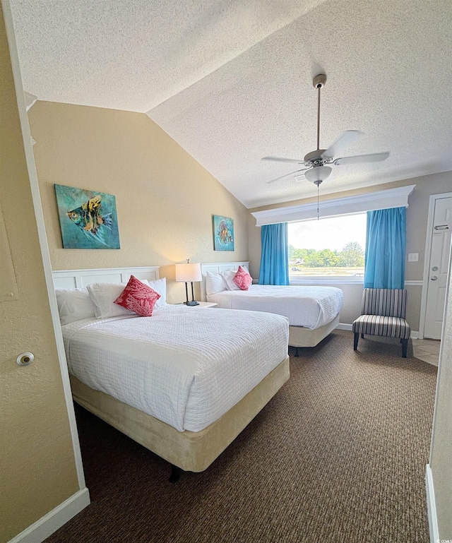 bedroom with vaulted ceiling, dark colored carpet, ceiling fan, and a textured ceiling