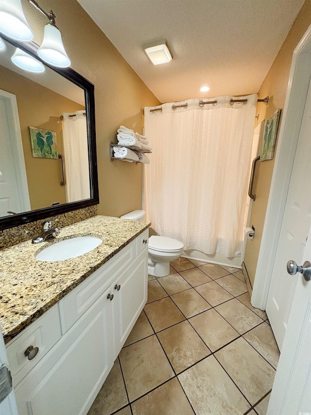 bathroom featuring tile floors, a textured ceiling, vanity, and toilet