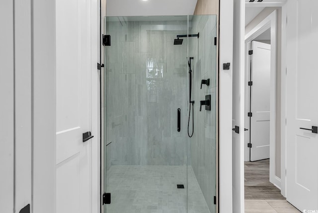 bathroom featuring wood-type flooring and a shower with door