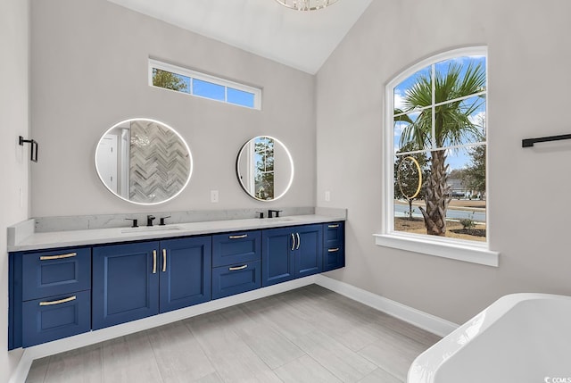 bathroom featuring a tub, a healthy amount of sunlight, and vaulted ceiling