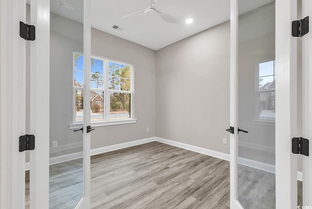 spare room featuring ceiling fan, light hardwood / wood-style flooring, and french doors