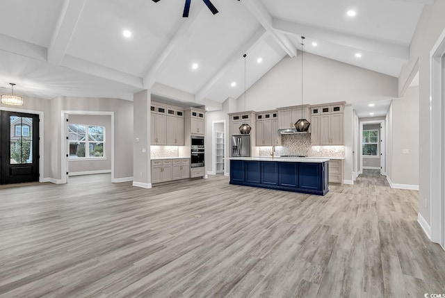 kitchen with tasteful backsplash, stainless steel fridge with ice dispenser, pendant lighting, a kitchen island with sink, and light wood-type flooring