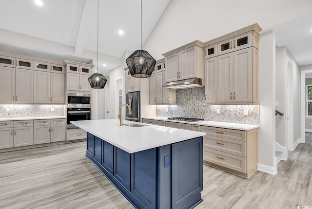 kitchen with decorative light fixtures, a kitchen island with sink, appliances with stainless steel finishes, and tasteful backsplash