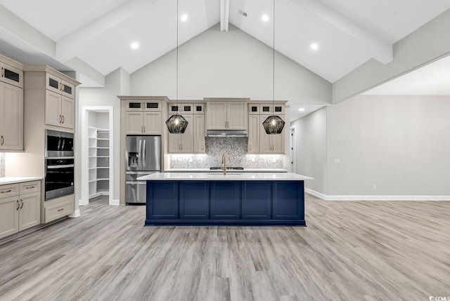 kitchen featuring decorative light fixtures, light wood-type flooring, a kitchen island with sink, and appliances with stainless steel finishes