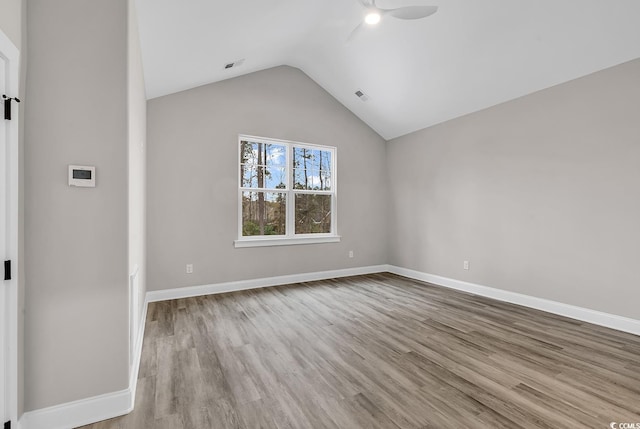 unfurnished room featuring vaulted ceiling and light hardwood / wood-style flooring