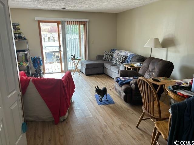 living room featuring a textured ceiling and wood finished floors