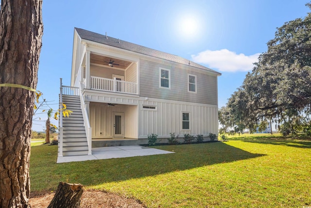 rear view of property with a lawn, ceiling fan, a balcony, and a patio