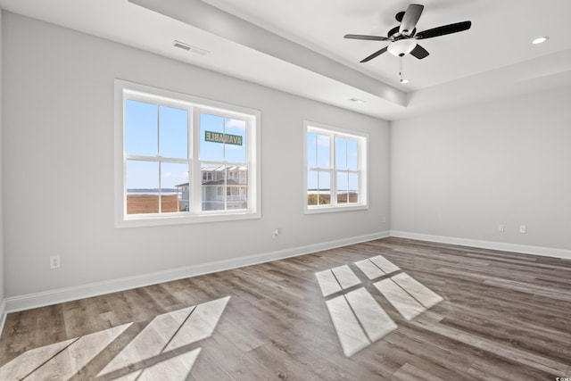 spare room featuring ceiling fan, visible vents, recessed lighting, wood finished floors, and baseboards