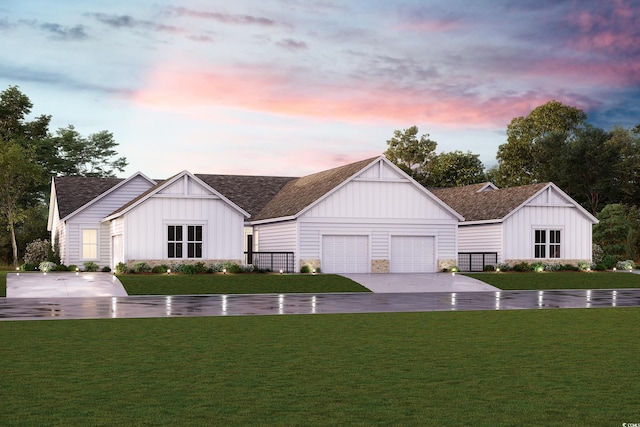 back house at dusk with a garage and a lawn