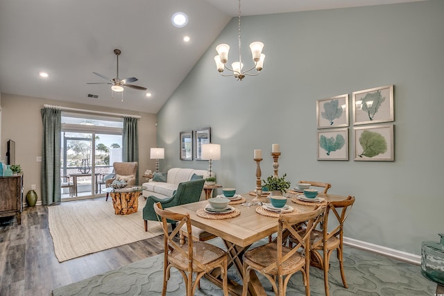 dining space with high vaulted ceiling, dark hardwood / wood-style floors, and ceiling fan with notable chandelier