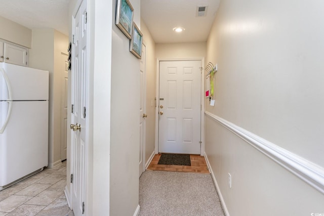 doorway featuring light carpet