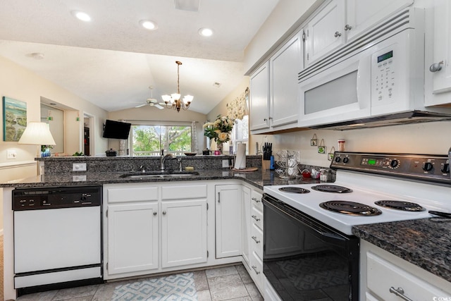 kitchen featuring white cabinetry, dark stone countertops, sink, white appliances, and lofted ceiling