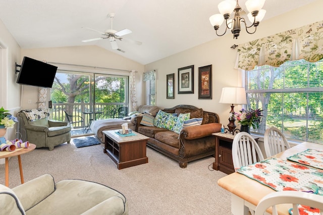 carpeted living room with ceiling fan with notable chandelier and vaulted ceiling