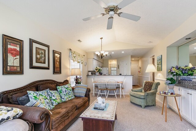 carpeted living room with vaulted ceiling and ceiling fan with notable chandelier