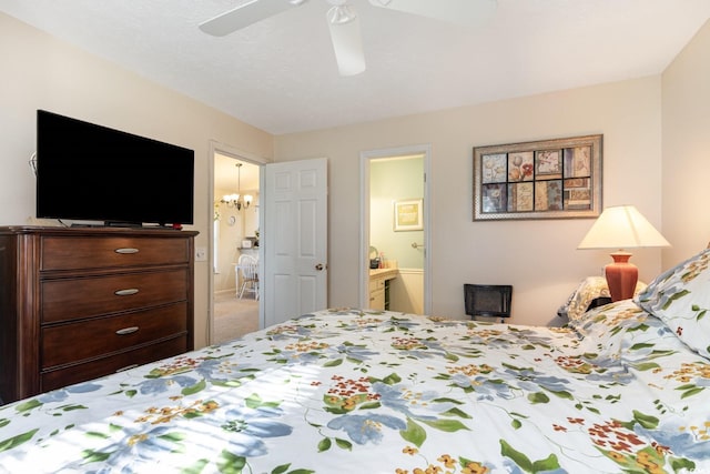 carpeted bedroom with ensuite bathroom and ceiling fan with notable chandelier