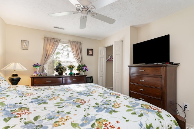 bedroom featuring ceiling fan and a textured ceiling