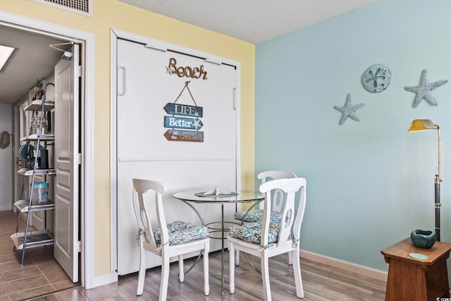 dining space with a textured ceiling and hardwood / wood-style floors