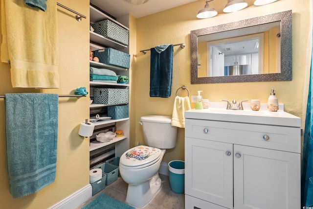 bathroom featuring tile flooring, vanity with extensive cabinet space, and toilet