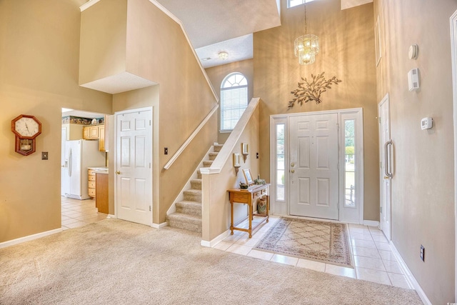 foyer with a towering ceiling, light carpet, and an inviting chandelier