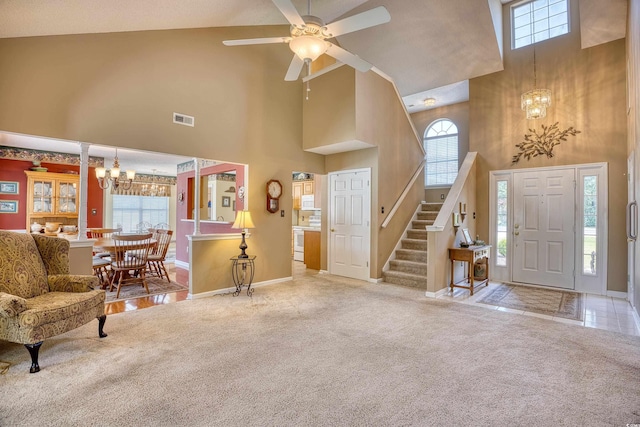 entrance foyer with ceiling fan, high vaulted ceiling, and light colored carpet