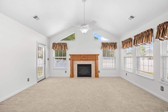 unfurnished living room featuring a high end fireplace, light carpet, ceiling fan, lofted ceiling, and baseboards