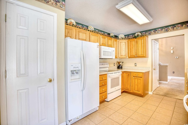 kitchen with a textured ceiling, white appliances, and light tile patterned flooring