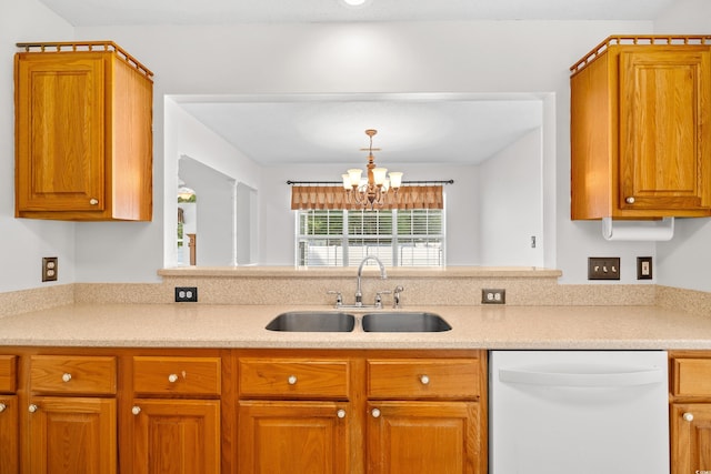 kitchen with dishwasher, a sink, a chandelier, and brown cabinetry