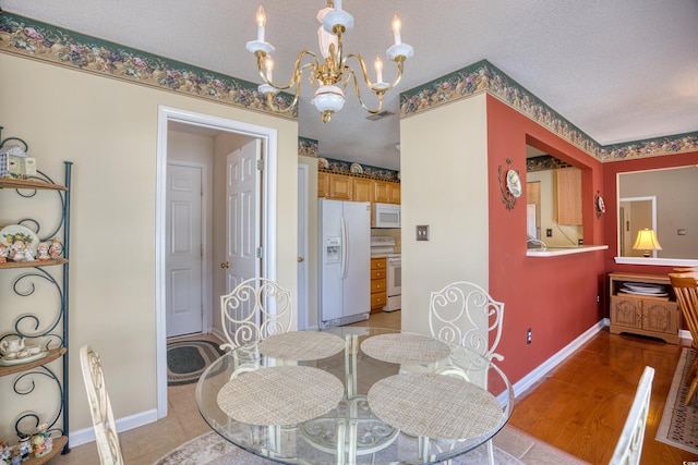 dining area with light hardwood / wood-style floors and a textured ceiling