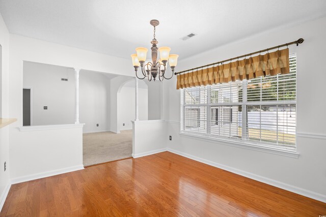 2513 Hunters Trl, Myrtle Beach, SC 29588 - unfurnished dining area featuring arched walkways, a chandelier, wood finished floors, and baseboards