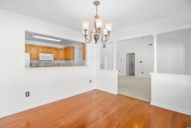 2513 Hunters Trl, Myrtle Beach, SC 29588 - unfurnished dining area with a chandelier, light wood-style flooring, baseboards, and a sink