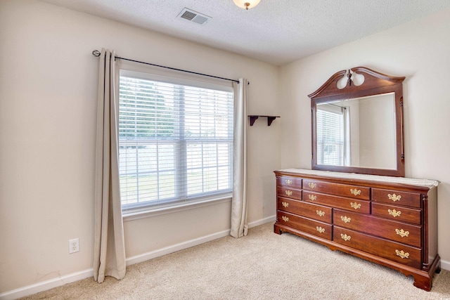 bedroom with light carpet and a textured ceiling