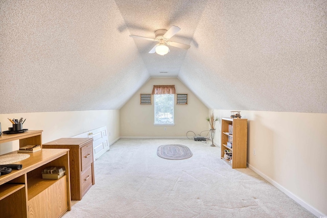 bonus room featuring a textured ceiling, light colored carpet, vaulted ceiling, and ceiling fan