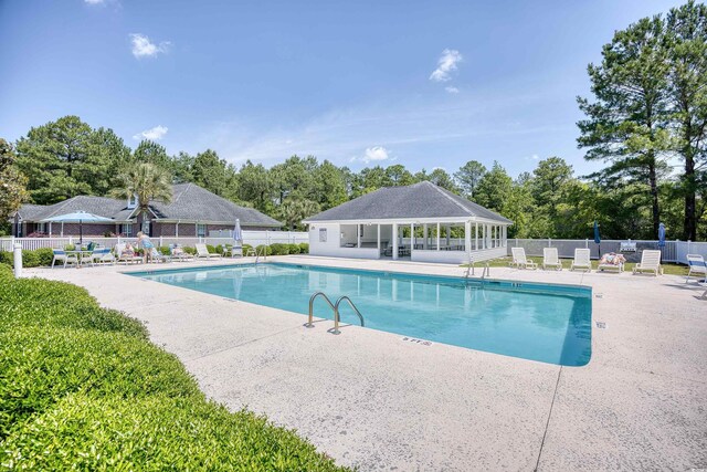 2513 Hunters Trl, Myrtle Beach, SC 29588 - community pool with a patio, fence, and view of scattered trees