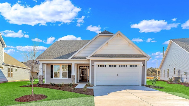 craftsman-style house featuring a front yard, central AC, and a garage