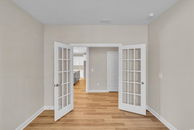 spare room with french doors and light wood-type flooring