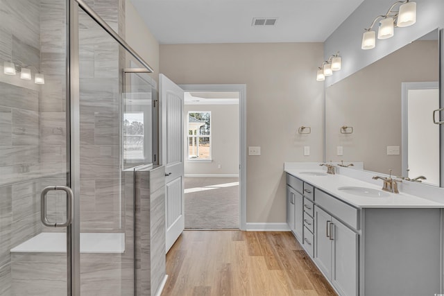 bathroom featuring hardwood / wood-style flooring, vanity, and walk in shower