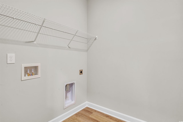 clothes washing area with electric dryer hookup, washer hookup, and wood-type flooring