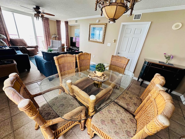 dining room featuring a textured ceiling, ornamental molding, tile flooring, and ceiling fan