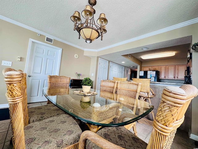 tiled dining space featuring a chandelier, a textured ceiling, and crown molding