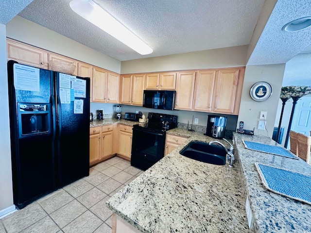 kitchen featuring black appliances, sink, light brown cabinetry, and light tile floors