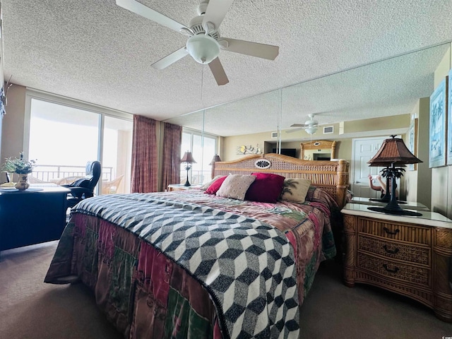 bedroom with ceiling fan, dark colored carpet, and a textured ceiling