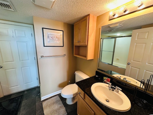 bathroom featuring tile floors, a textured ceiling, toilet, and large vanity