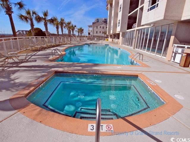 view of pool with a patio and a hot tub