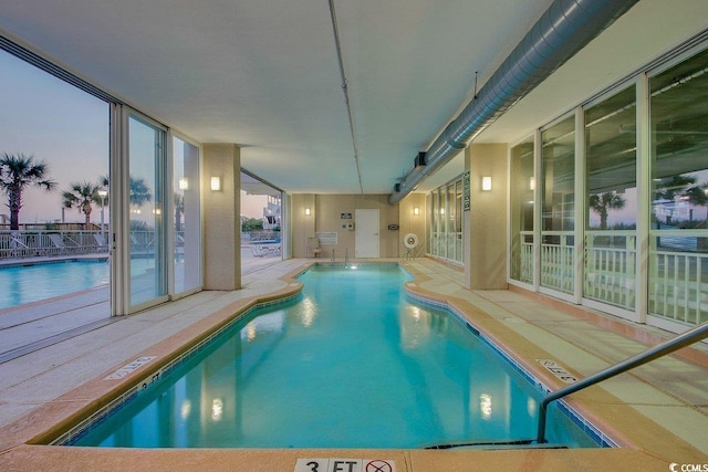 pool at dusk featuring a patio